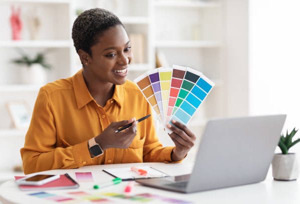 Pretty short-haired young black woman lecturer having video call with her students, pointing at color palettes in her hand, making online lesson, designer having video chat with client, copy space